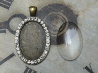 Glascabochon oval, bronze, Rahmen m. Strass außen Glascabochon oval, bronze, Rahmen m. Strass außen